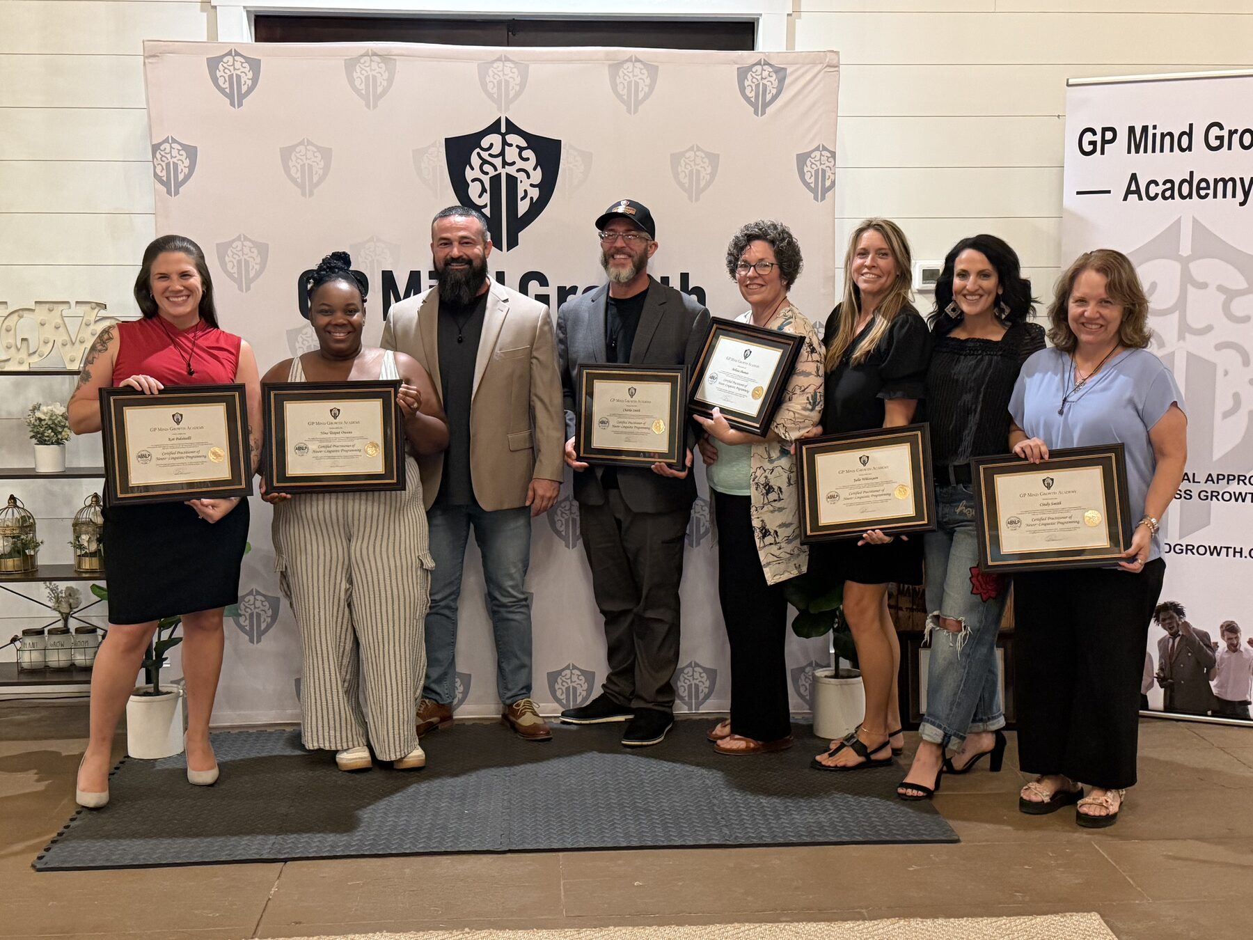 GP Mind Growth Academy graduates holding their framed NLP certificates with Greg Pihs