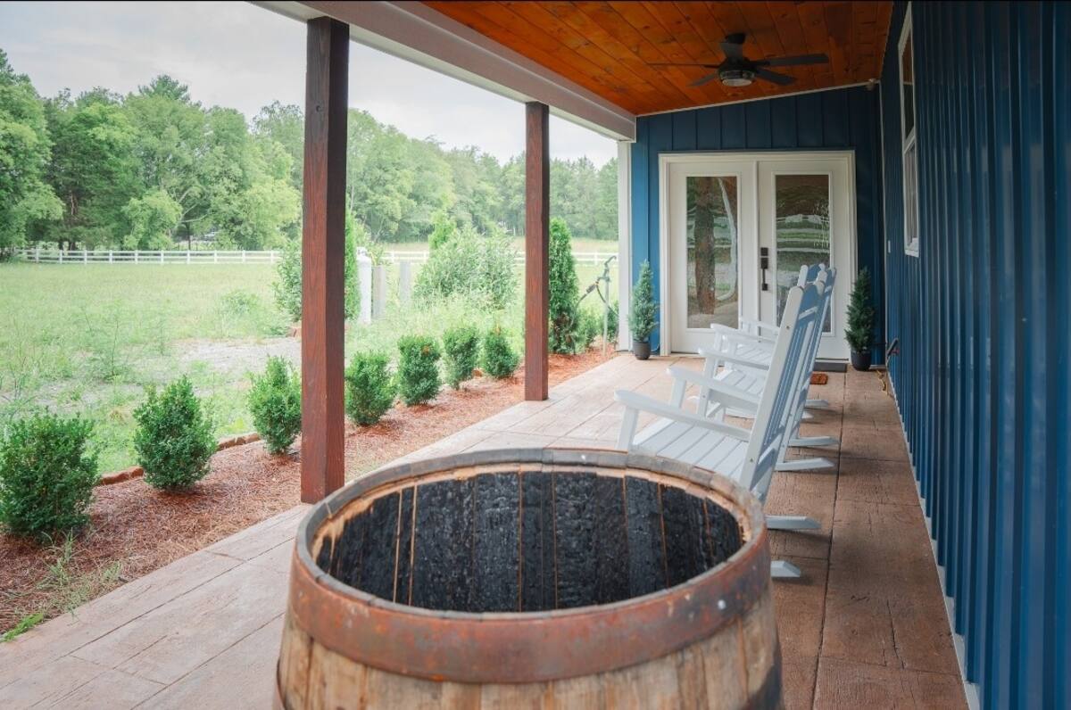 Covered porch with rocking chairs overlooking the pasture